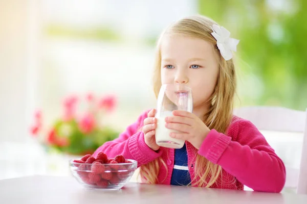 Söt liten tjej dricka mjölk hemma — Stockfoto