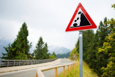 Düşen Alman Alpleri'nde dolambaçlı yol yol işareti kayalar. Uyarı yol işareti dağlarda. Bavyera, Almanya.