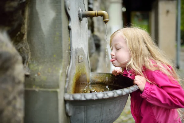 ドイツのリンダウに飲料水の噴水で遊ぶ愛らしい少女 — ストック写真