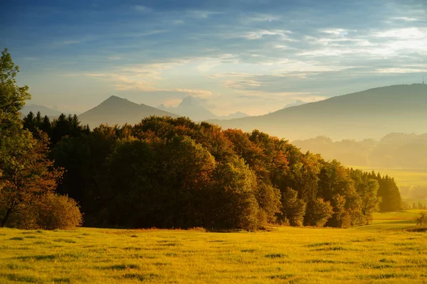 Sonbahar akşamında Avusturya Merkez Alplerdeki pastoral yeşil alanlar üzerinde dramatik gökyüzü.