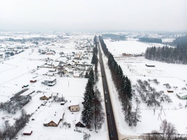 Çam ormanlarının karla kaplı olduğu güzel bir hava manzarası ve ağaçların arasında dönen bir yol. Rime buzu ve ağaçları kaplayan buz kütleleri. Vilnius, Litvanya 'da manzara.