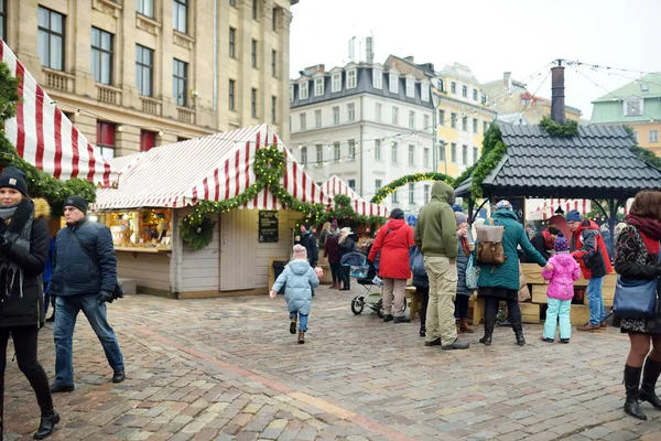 Riga, Lotyšsko - 17. prosince 2018: Lidé si užívají nejautentičtější trh v Rize a nabídne desítky řemesel a stánků s jídlem, stejně jako obří vánoční stromeček. — Stock fotografie