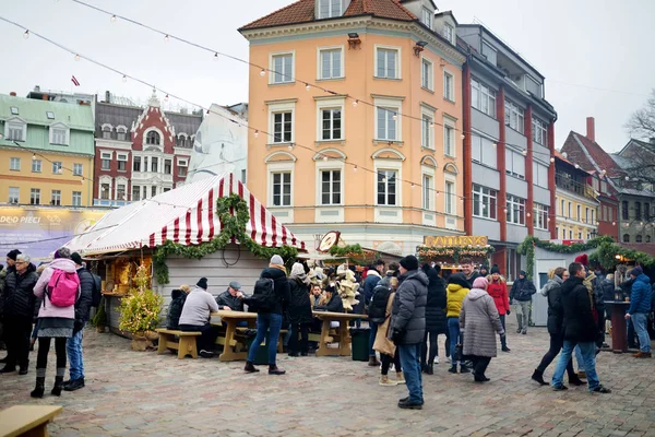 RIGA, LATVIA - 17 DE DICIEMBRE DE 2018: La gente disfrutará del mercado más auténtico de Riga y ofrecerá docenas de puestos de artesanía y comida, así como un árbol de Navidad gigante . — Foto de Stock