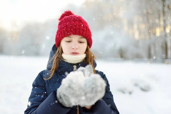 Чарівна молода дівчина розважається в прекрасному зимовому парку. Мила дитина грає на снігу. Зимові заходи для сім'ї з дітьми . — стокове фото