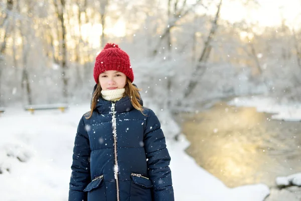 Αξιολάτρευτο κορίτσι που διασκεδάζει στο όμορφο χειμερινό πάρκο. Χαριτωμένο παιδί που παίζει στο χιόνι. Χειμερινές δραστηριότητες για οικογένειες με παιδιά. — Φωτογραφία Αρχείου