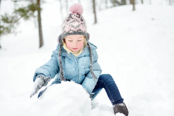 Entzückende junge Mädchen, die Spaß im schönen Winterpark haben. niedliches Kind, das im Schnee spielt. Winteraktivitäten für Familien mit Kindern. — Stockfoto