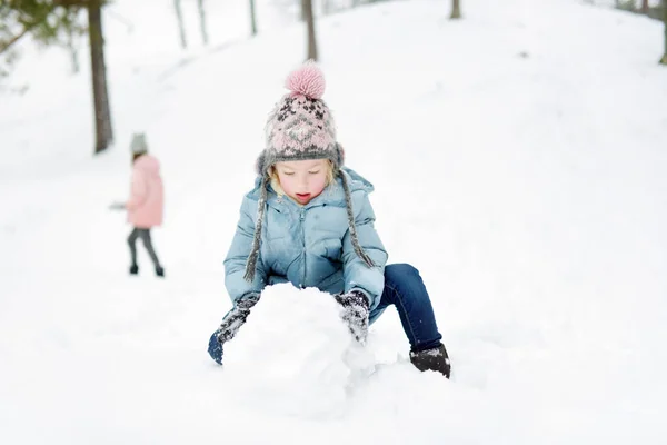 Söt ung flicka som har roligt i vackra vinterpark. Söta barn som leker i snö. Vinteraktiviteter för barnfamiljer. — Stockfoto