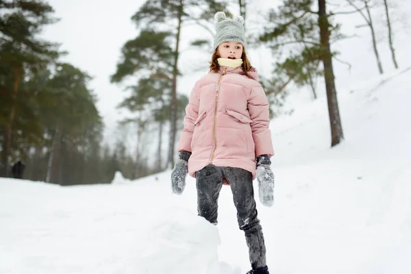 Adorável jovem garota se divertindo no belo parque de inverno. Criança bonita brincando em uma neve. Atividades de inverno para a família com crianças . — Fotografia de Stock