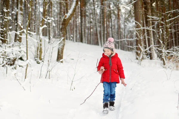 Sevimli genç kız güzel kış parkında eğleniyor. Karda oynayan sevimli bir çocuk. Çocuklu aileler için kış etkinlikleri. — Stok fotoğraf