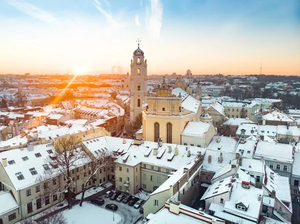 Bellissimo panorama della città di Vilnius in inverno con case innevate, chruches e strade. Vista aerea serale . — Foto Stock