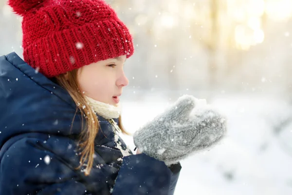 Schattig jong meisje dat zich vermaakt in een prachtig winterpark. Schattig kind dat in de sneeuw speelt. Winteractiviteiten voor familie met kinderen. — Stockfoto