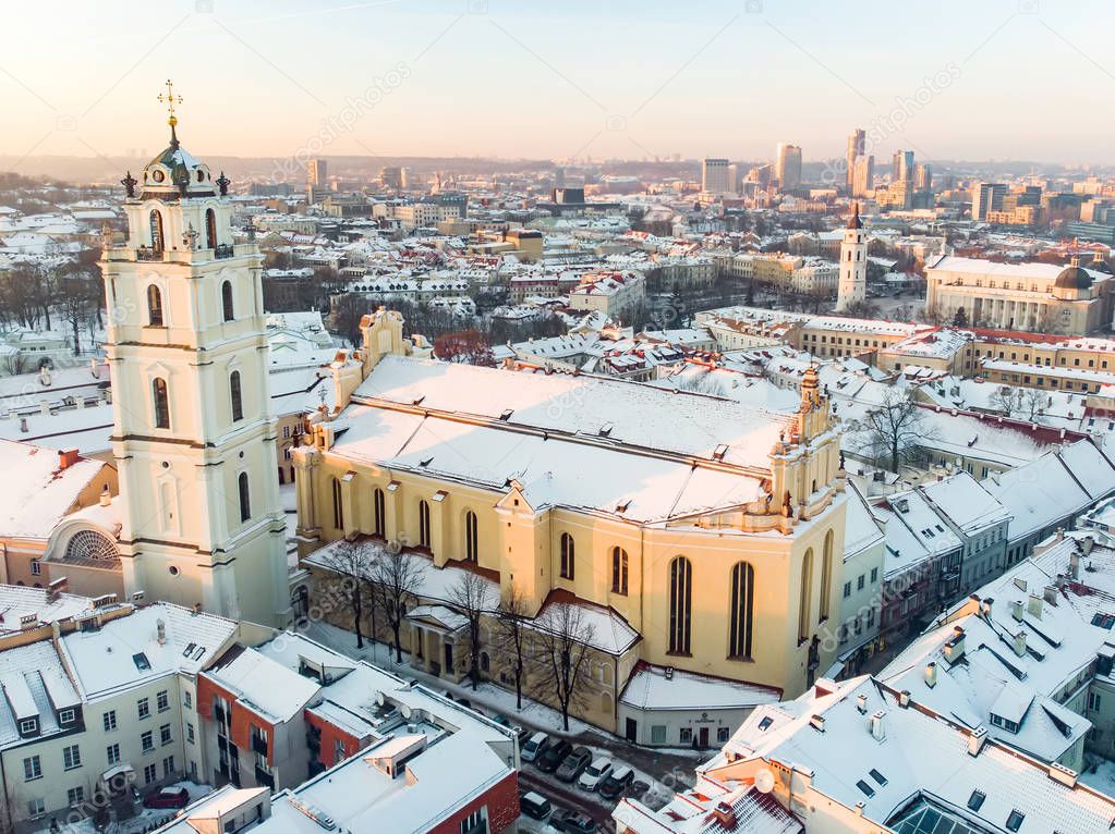 Beautiful Vilnius city panorama in winter with snow covered houses, chruches and streets. Aerial evening view.