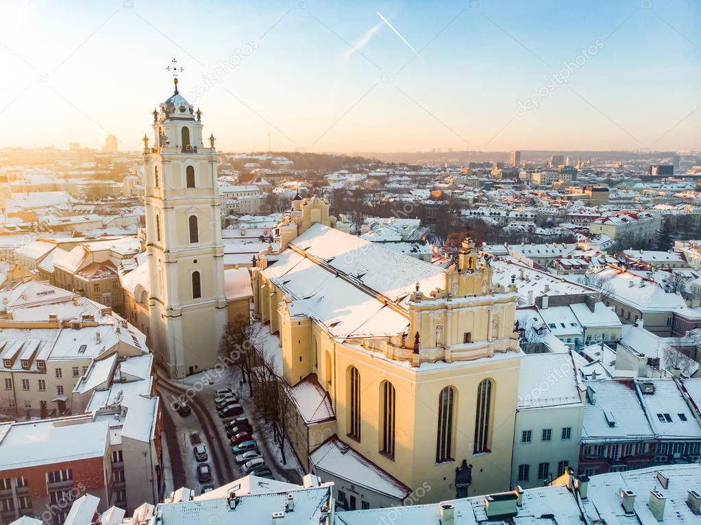 Beautiful Vilnius city panorama in winter with snow covered houses, chruches and streets. Aerial evening view.