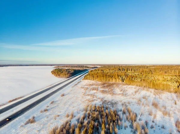 숲 사이 의 2 차선 도로로 덮여 있는 아름다운 눈의 공중 풍경. 나무를 덮고 있는 얼음 과 서리. — 스톡 사진