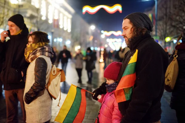 VILNIUS, LITUANIA - 16 DE FEBRERO DE 2018: Cientos de personas asisten a la celebración del Día de la Restauración del Estado en Vilna. Las hogueras se encienden en la avenida Gediminas en la noche del 16 de febrero . — Foto de Stock
