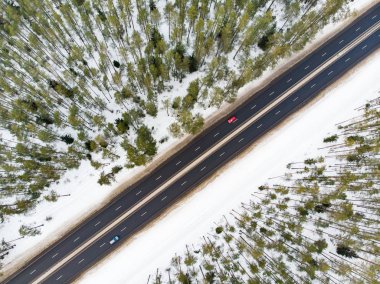 Ağaçlar arasında iki şeritli bir yol olan karla kaplı güzel bir hava manzarası. Rime buzu ve ağaçları kaplayan buz kütleleri. Vilnius, Litvanya yakınlarındaki manzaralı kış manzarası.