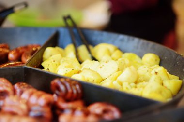 Litvanya 'nın Vilnius kentindeki bahar pazarında geleneksel kızarmış patatesler pişiriliyor. Paskalya panayırında çeşitli lezzetli sokak yemekleri.