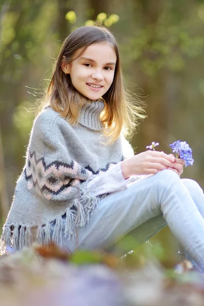 美しい晴れた春の日に森の中で春の最初の花を選ぶ愛らしい若い女の子. — ストック写真