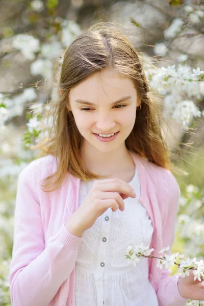 Adorable niña en el jardín de manzanos en flor en hermoso día de primavera . —  Fotos de Stock