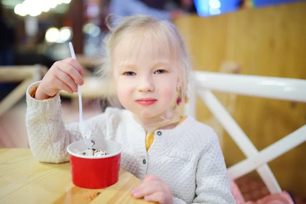 Schattig klein meisje dat lekker vers ijs binnen eet. Kindersnoepjes eten. — Stockfoto