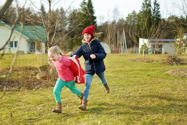 Two young sisters having fun together on beautiful spring day. Active family leisure with kids. Family fun outdoors. — Stock Photo, Image