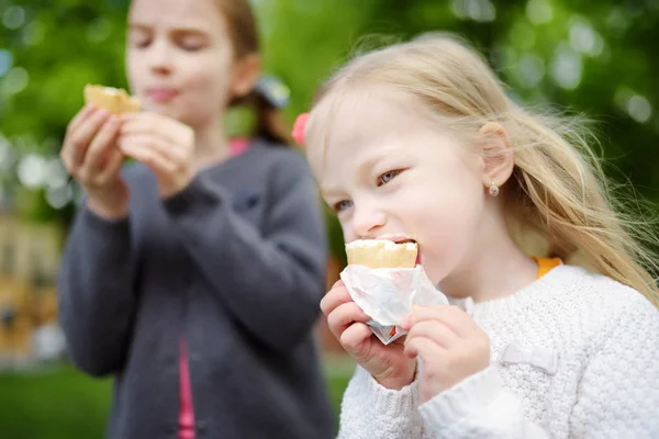 Słodkie małe dzieci jedzące smaczne świeże lody w kawiarni na świeżym powietrzu. Dzieci jedzące słodycze. — Zdjęcie stockowe