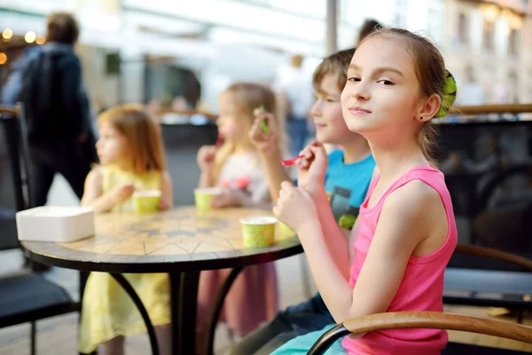 Lindos niños pequeños comiendo sabroso helado fresco en la cafetería al aire libre. Niños comiendo dulces . —  Fotos de Stock