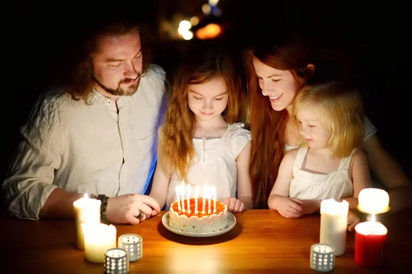 誕生日ケーキにキャンドルを吹く前に願い事をするかわいい7歳の女の子。誕生日を祝う子供. — ストック写真