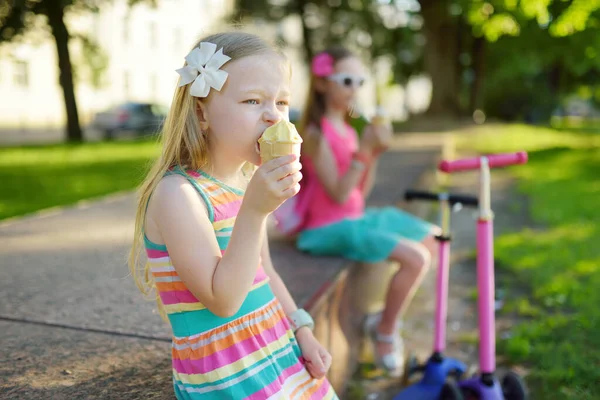 Lindos niños pequeños comiendo sabroso helado fresco en el soleado parque de verano. Niños comiendo dulces . —  Fotos de Stock
