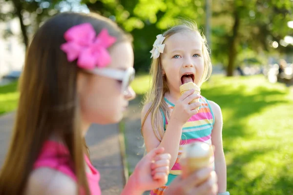 Słodkie małe dzieci jedzące smaczne świeże lody w słonecznym letnim parku. Dzieci jedzące słodycze. — Zdjęcie stockowe