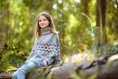 Güzel, güneşli bir bahar gününde ormanda ilkbaharın ilk çiçeklerini toplayan sevimli genç kız. Şirin çocuk dışarıda eğleniyor. Doğayı keşfeden çocuk.