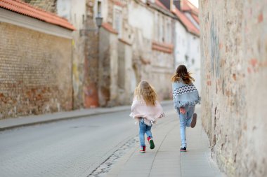 İki tatlı genç kız kardeş güzel bir bahar gününde şehirde birlikte eğleniyorlar. Çocuklarla aktif aile eğlencesi. Aile eğlencesi..