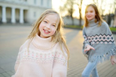 İki tatlı genç kız kardeş güzel bir bahar gününde şehirde birlikte eğleniyorlar. Çocuklarla aktif aile eğlencesi. Aile eğlencesi..