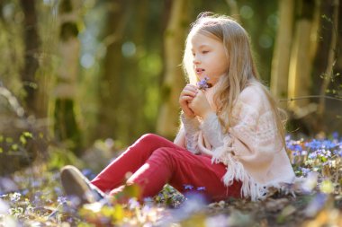 Güzel, güneşli bir bahar gününde ormanda ilkbaharın ilk çiçeklerini toplayan sevimli genç kız. Şirin çocuk dışarıda eğleniyor. Doğayı keşfeden çocuk.