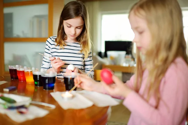 两个可爱的年轻姐妹在家里染复活节彩蛋 孩子们为复活节狩猎画五颜六色的彩蛋 孩子们准备复活节庆祝活动 家庭传统 — 图库照片