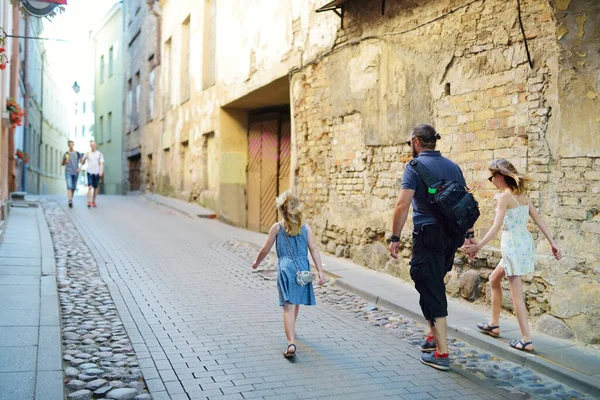 两个可爱的小女孩和她们的父亲在立陶宛维尔纽斯的大街上 在温暖而阳光明媚的夏日观光 — 图库照片