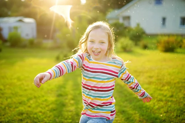 Schattig Jong Meisje Dat Speelt Met Een Sprinkler Een Achtertuin — Stockfoto