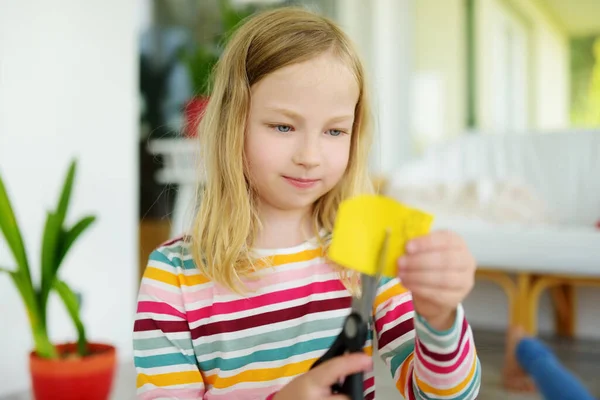 小女孩在家里用剪刀剪彩纸 有创意的孩子在做手工艺 儿童的教育和远距离学习 检疫期间在家学习 待在家里娱乐 — 图库照片