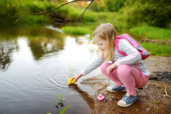 可爱的小女孩在河边和五颜六色的橡胶鸭玩耍 孩子们在温暖的夏日与水一起玩乐 家庭户外休闲活动 — 图库照片