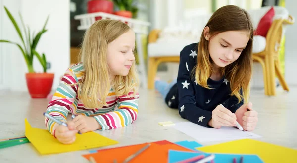 カラフルな鉛筆で絵を描く2人の妹 創造的な子供たちは一緒に工芸品をする 子供のための教育と距離学習 隔離中のホームスクーリング ホームエンターテイメントに滞在する — ストック写真