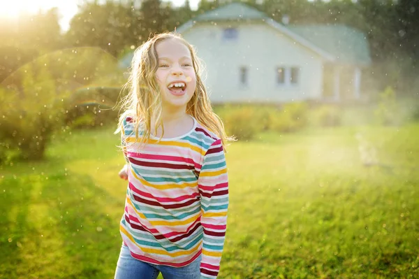 여름날 뒷마당에서 스프링클러 랑놀고 귀여운 귀여운 야외에서 즐기고 있습니다 아이들을 — 스톡 사진