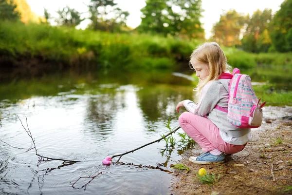 Χαριτωμένο Νεαρό Κορίτσι Παίζει Δίπλα Ένα Ποτάμι Πολύχρωμες Πάπιες Καουτσούκ — Φωτογραφία Αρχείου