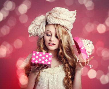 hediye kutusu pembe bir arka plan üzerinde bir kız bebek.