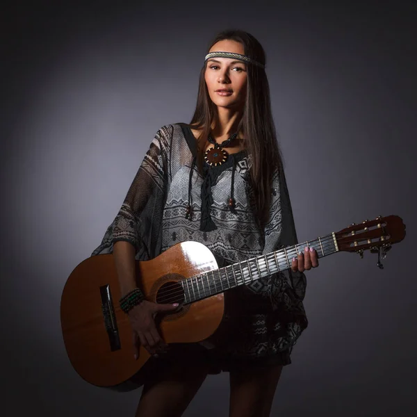 Ragazza hippie con una chitarra tra le mani posa in Studio . — Foto Stock