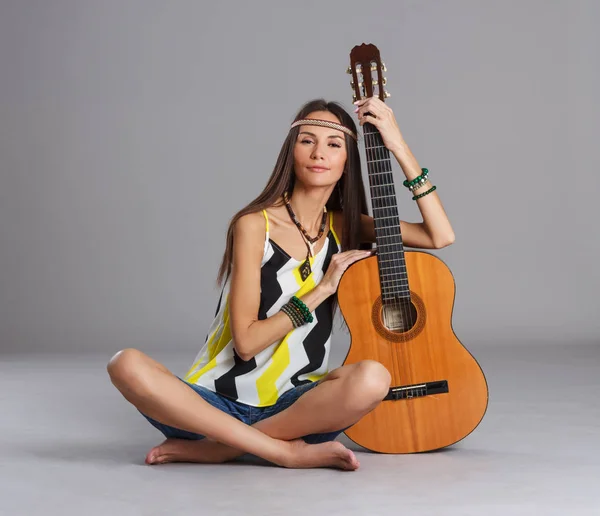 Giovane donna seduta con una chitarra — Foto Stock