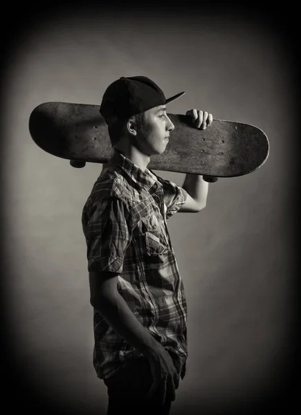 Teen skate boarding on a dark background. — Stock Photo, Image