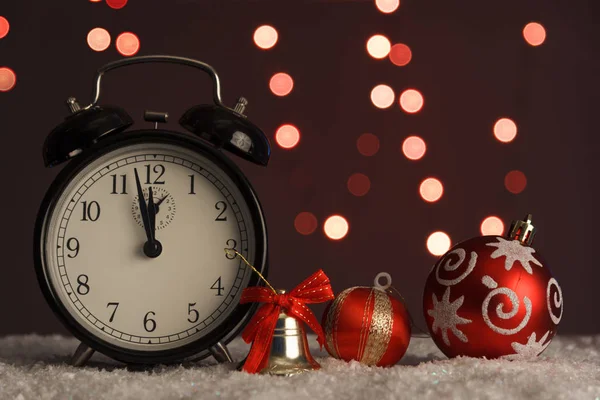 Reloj despertador sobre fondo de luces navideñas . — Foto de Stock