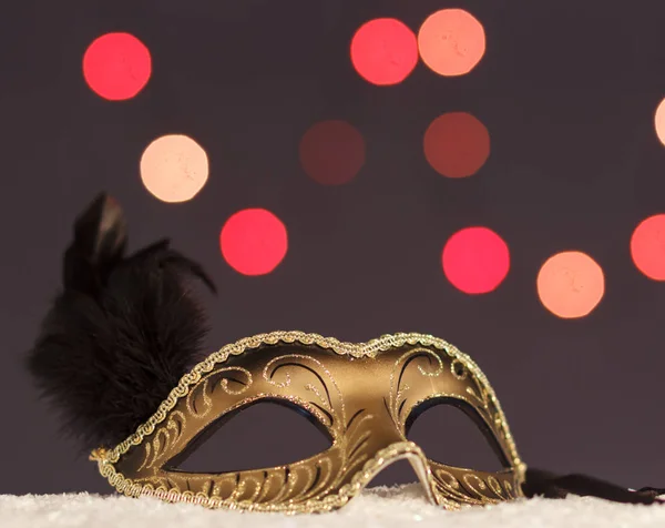 Karnevalsmaske vor dem Hintergrund der Weihnachtsbeleuchtung. — Stockfoto