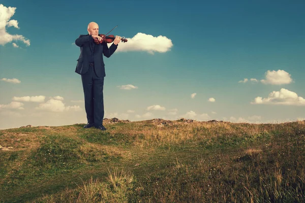 Пожилой человек играет на скрипке на открытом воздухе . — стоковое фото