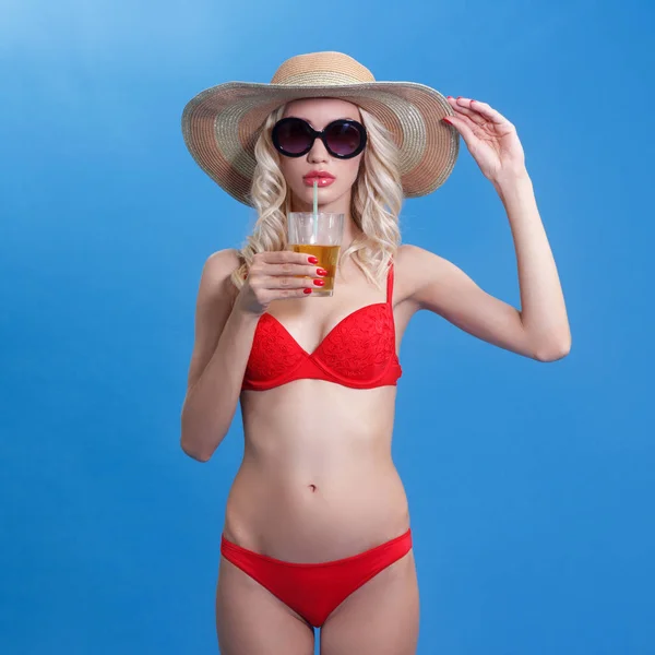 Giovane donna di lusso in bikini rosso con un cocktail in mano . — Foto Stock